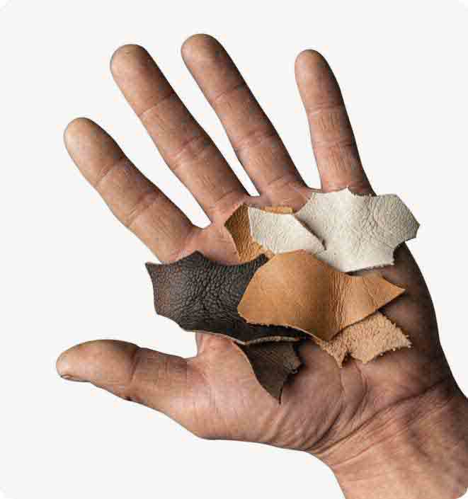 A hand holding recycled leather swatches